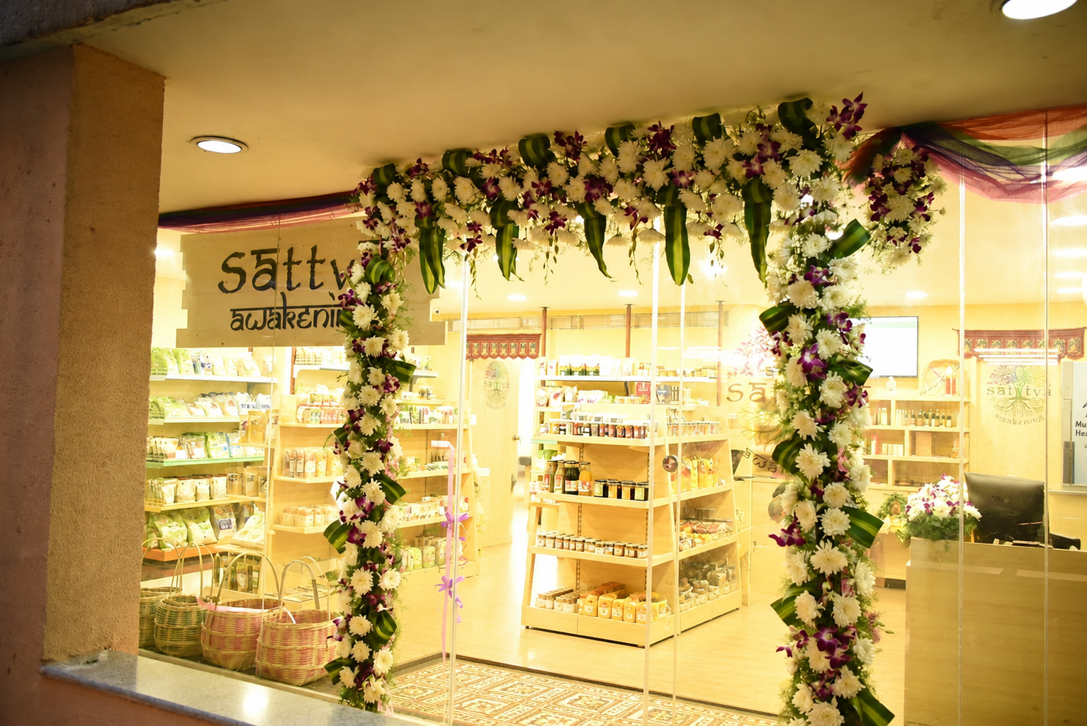 Sattva Awakening storefront adorned with floral garlands welcoming visitors